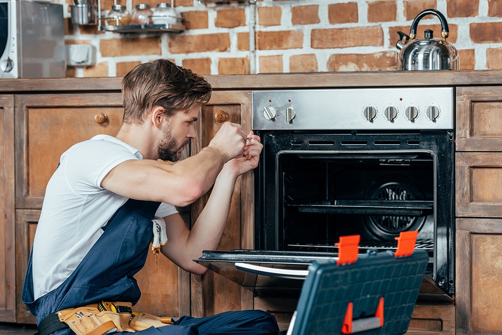 man fixing stove